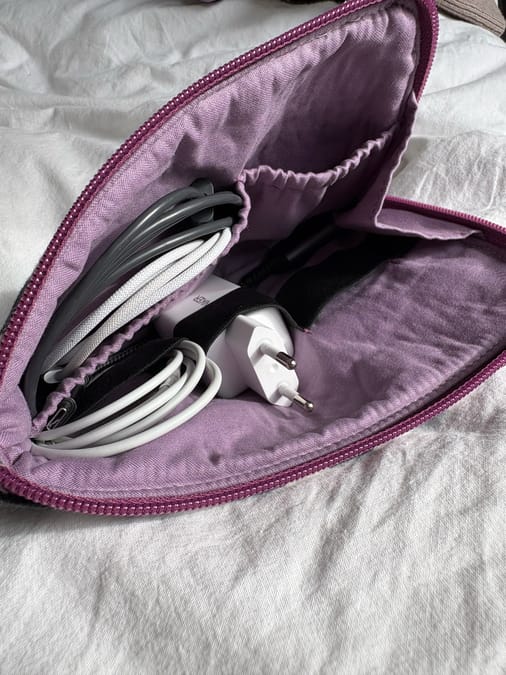 Detail of handmade cable organizer pouch with elastic loops holding cables and chargers