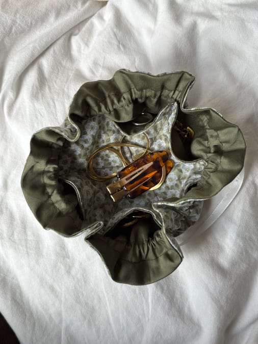 Handmade fabric jewelry pouch open showing earrings and jewelry inside