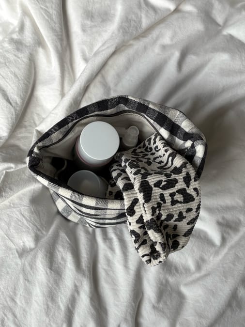 Close-up detail of a handmade skincare and makeup bag with elastic straps inside
