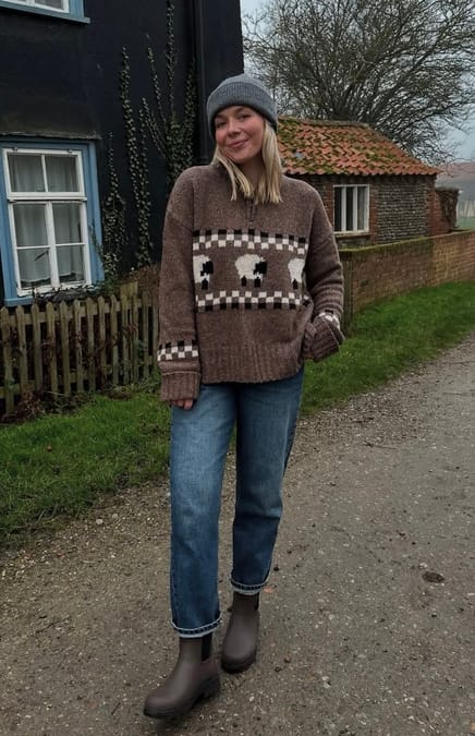 Woman in brown knitted sweater with fun pattern and sheep on it
